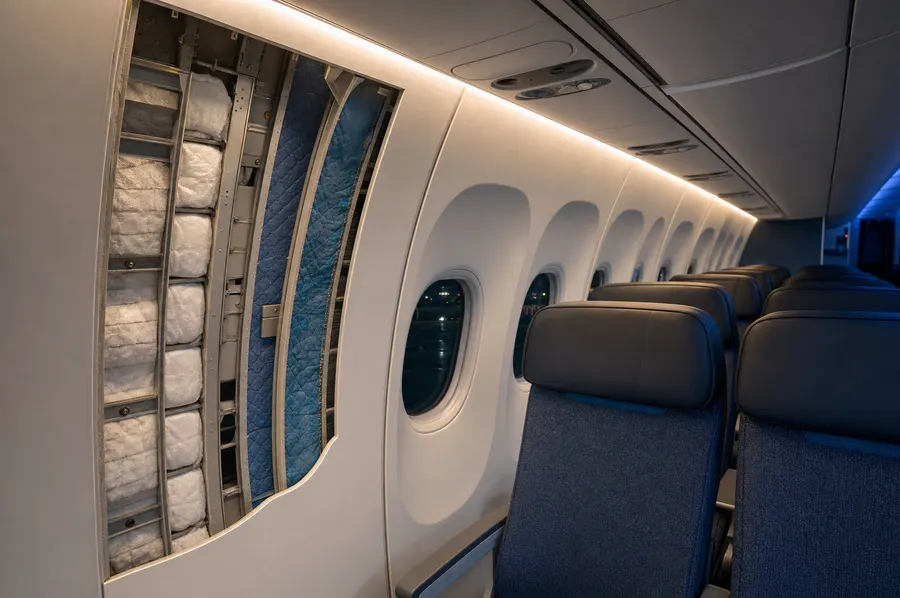 Aircraft cabin wall opened to show the insulation layers behind the trim panel